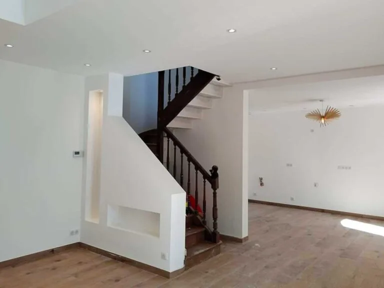 Escalier intérieur rénové avec des finitions modernes en bois et blanc, projet de rénovation à Quimper.